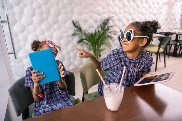 Lindos hermanos divertidos con gafas de sol brillantes jugando juegos en sus tabletas — Foto de Stock