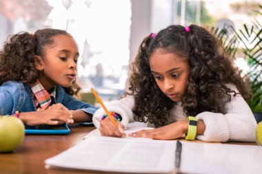 Kıvırcık kız öğrenci ödevini yapıyor sarı akıllı saati