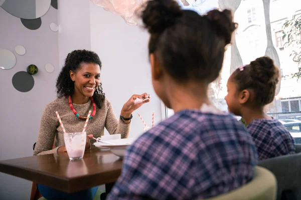 Cuidar radiante madre hablando con sus niñas encantadoras en la cafetería — Foto de Stock