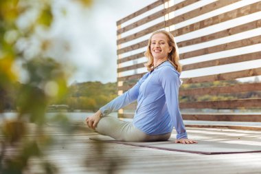 Neşeli kadın yoga yaparak onun sırt kasları germe