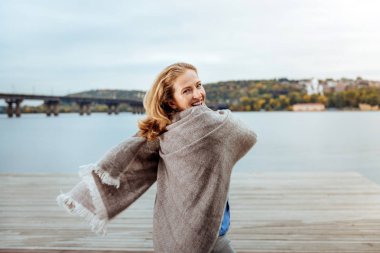 Sıcak bir ekose gülümseyen kadın sarılmış