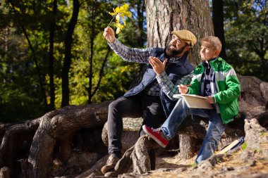 Bir meşe dalı tutan mutlu neşeli adam