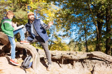 Ormanda olurken notlar alarak neşeli akıllı çocuk