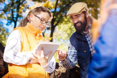 Pozitif sakallı adam çocuklar defterini işaret