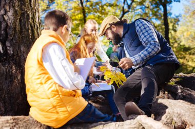 Ağaç dalı çizimlerinin yapıyor güzel şirin çocuk