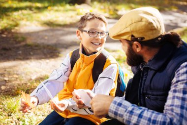 Bir akçaağaç yaprağı holding neşeli mutlu çocuk