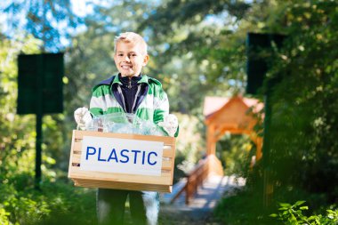 Neşeli sevimli çocuk parkta Plastik temizlik