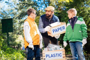 Bir kutu kağıt için tutan güzel neşeli adam