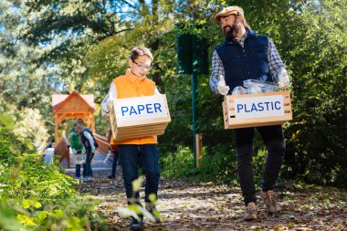 Güzel pozitif adam çöp götürmek için bir çocuk yardım