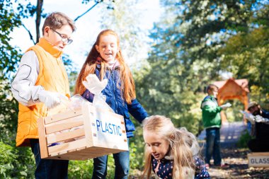 Plastik şişeler için bir kutu tutan güzel yakışıklı