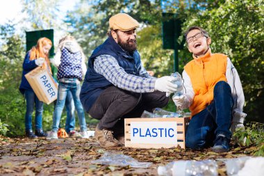 Pozitif güzel genç çocuk plastik şişe toplama