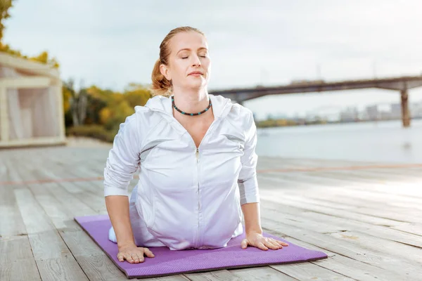 Mujer joven estirando la espalda mientras hace yoga — Foto de Stock