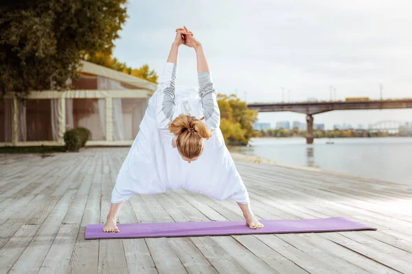 Молодая женщина растягивает мышцы спины упражнениями йоги — стоковое фото