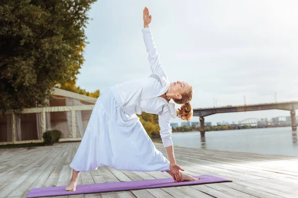Sabah yoga yaparken üçgen poz duran kadın