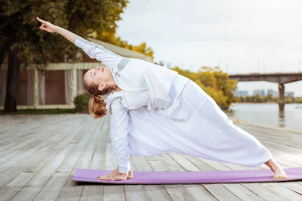 Sakin ve kendinden emin kadın Yoga pratik açık poz veriyor