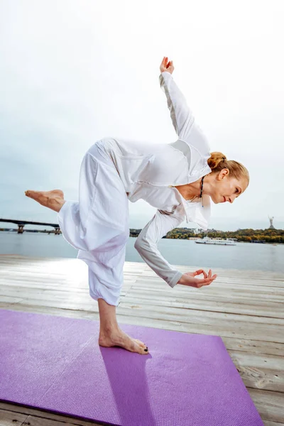 Mujer manteniendo el equilibrio mientras está de pie en pose de yoga — Foto de Stock