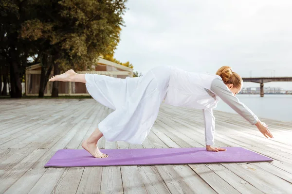 Woman easily keeping the balance while practising yoga pose