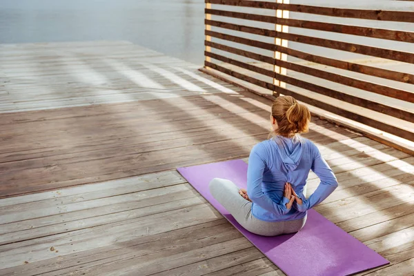 Sabah yoga yaparken katlanmış avuç içi kadınla