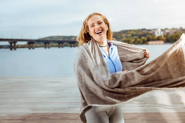 Giovane donna felice indossa plaid vicino al fiume — Foto Stock