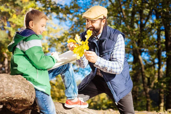 Chico feliz positivo dibujando una rama de árbol — Foto de Stock