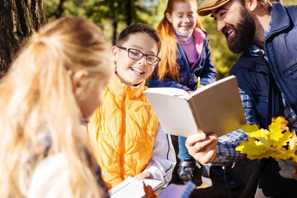 Gioioso ragazzo felice guardando nel libro — Foto Stock