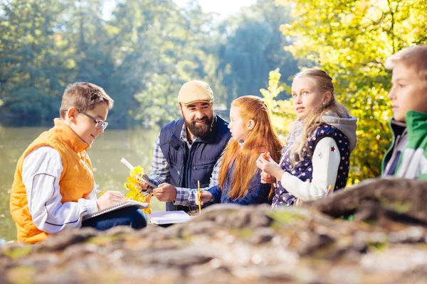 Niza jóvenes alumnos explorando el bosque juntos — Foto de Stock