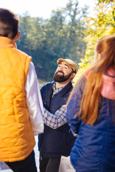 Agradable hombre positivo sonriendo a sus jóvenes pupilos —  Fotos de Stock