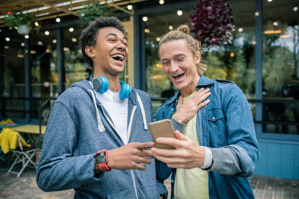 Positiv trevliga män tittar på roliga bilden — Stockfoto