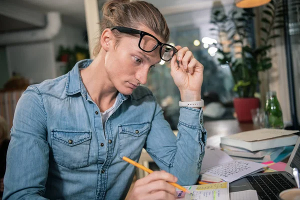 Niza inteligente joven sosteniendo sus gafas — Foto de Stock