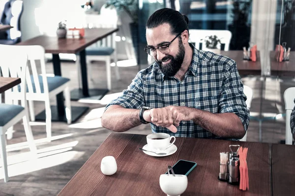 Successful busy businessman checking time while having meeting