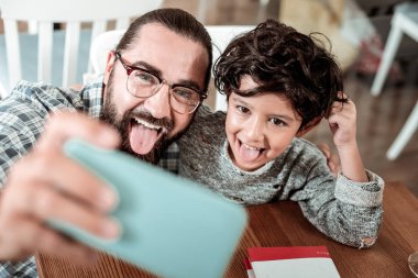 Kara gözlü baba ve oğul birlikte selfie yapım onların dillerini gösterilen