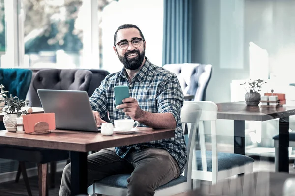 Successful businessman working remotely sitting in restaurant