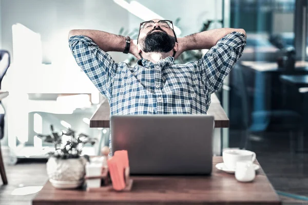 Bebaarde freelance schrijver met een minuut rust werkt in restaurant — Stockfoto