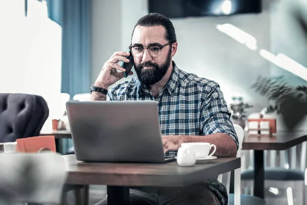 Mooie donker-eyed zakenman werken op afstand bellen zijn werknemer — Stockfoto