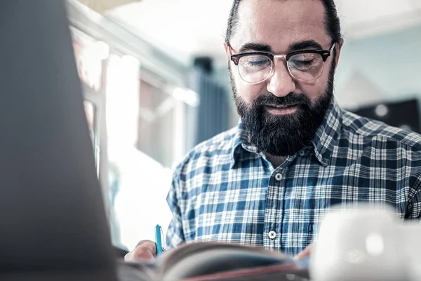 Närbild av mörkhårig man glasögon som läser boken — Stockfoto