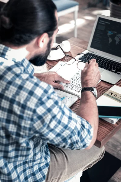 Mörkhårig man sitter framför sin bärbara dator medan du studerar kinesiska — Stockfoto