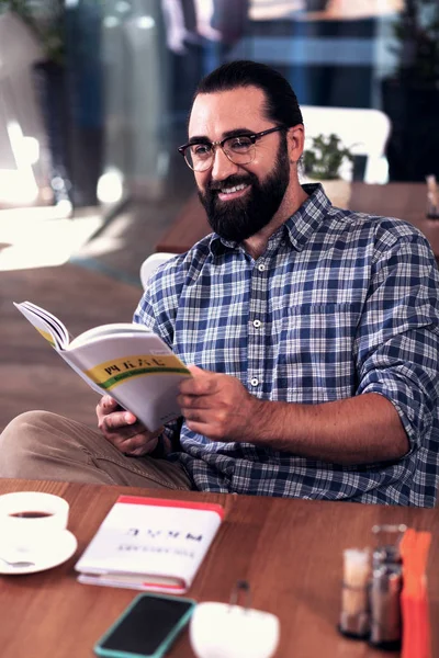Mörkhårig man bär glasögon håller bok studerar främmande språk — Stockfoto