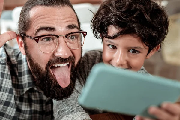 Divertido barbudo padre posando para selfie con su lindo hijo guapo —  Fotos de Stock