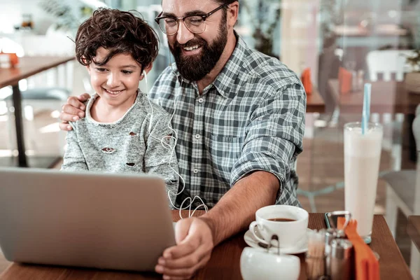 Vader en zoon kijken naar video op laptop na het drinken — Stockfoto
