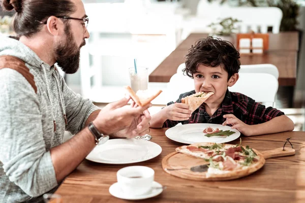 Щасливий батько і син обідали в кафетерії їдять смачну піцу — стокове фото