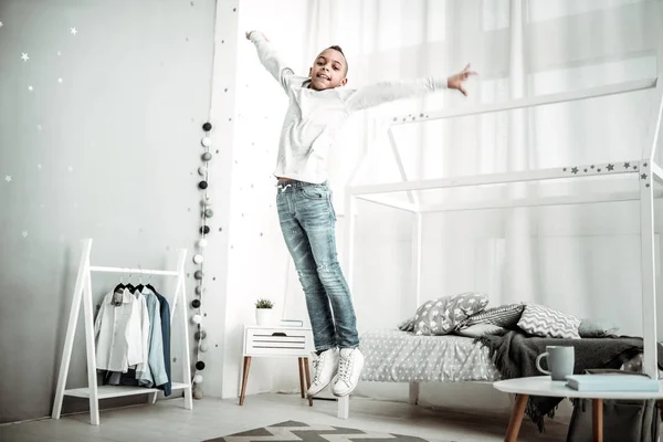 Alegre feliz menino pulando em seu quarto — Fotografia de Stock