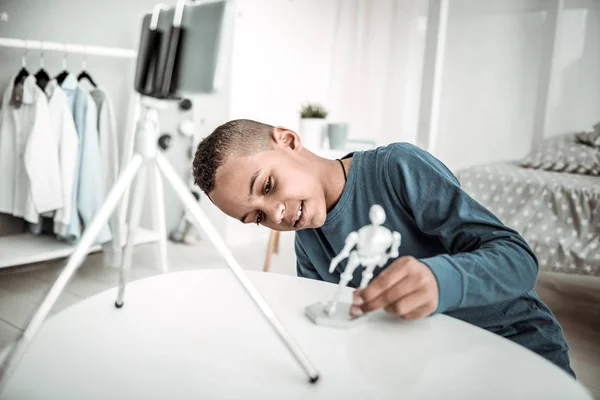 Positiv trevlig pojke plätering med ett mänskligt skelett leksak — Stockfoto