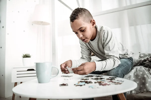 Angenehmer kleiner Junge mit einem Puzzleteil — Stockfoto