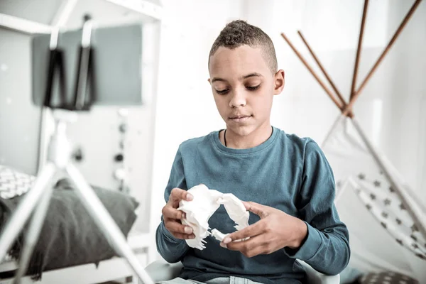 Un joven serio mirando el modelo de dinosaurio —  Fotos de Stock