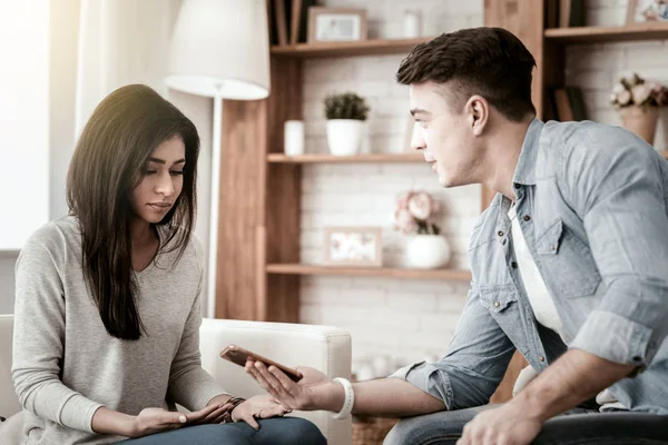 Upprörda unga kvinnliga sitter mittemot hennes partner — Stockfoto