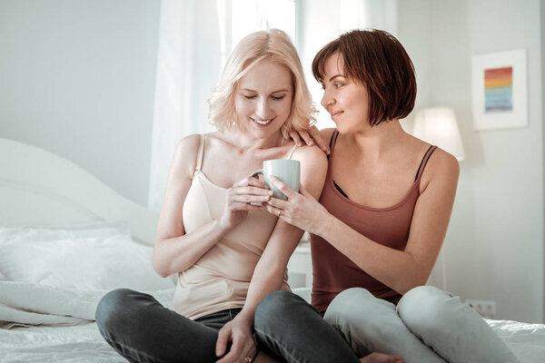 Beautiful same sex couple sitting on their bad