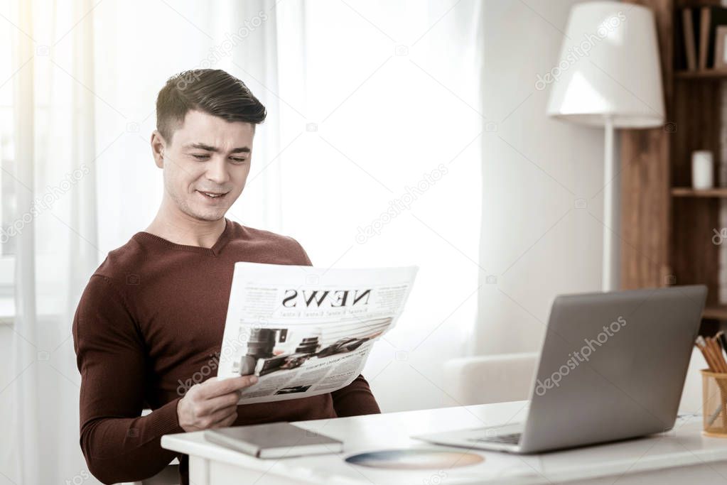 Pleased young man checking news in the country