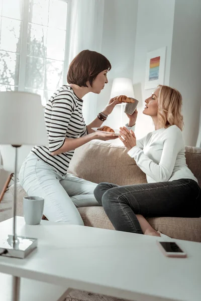 Två vackra damer som sitter i soffan på sina lägenheter — Stockfoto