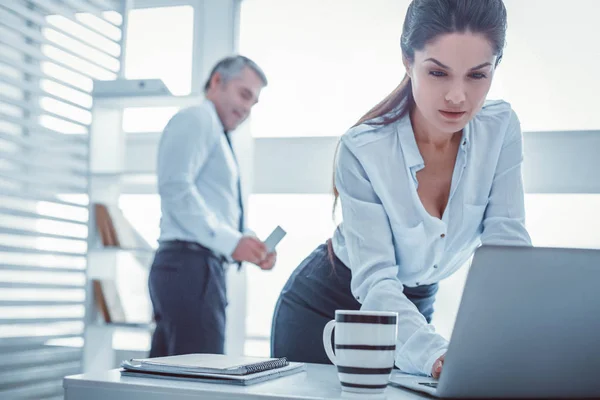 Langhaarige schöne Frau arbeitet mit Laptop im Büro — Stockfoto