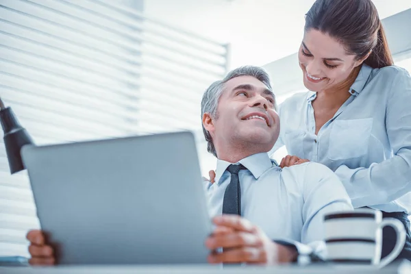 Freudige Partner, die eine romantische Beziehung bei der Arbeit haben — Stockfoto